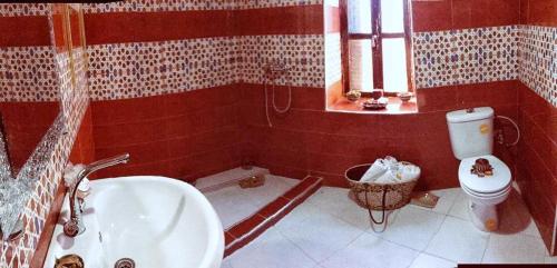 a bathroom with a tub and a toilet and a sink at Riad Yenna in Marrakech