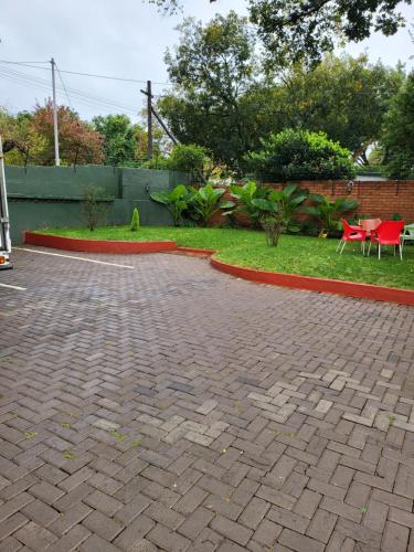 a brick driveway with a table and chairs in a yard at G On M Guest House in Pretoria