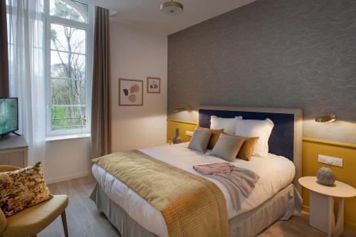 sypialnia z dużym łóżkiem i oknem w obiekcie DOMITYS - Manoir Maison Douaud w mieście Vannes