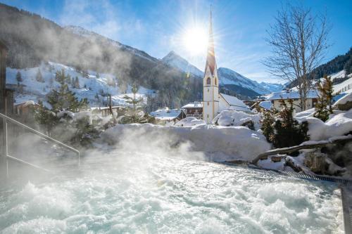 a snow covered village with a hot spring and a church at Alpendorf Anno Dazumal in Tux