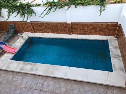 een groot zwembad met een glijbaan in een achtertuin bij Apartamento con piscina en Ciudad Jardín in Málaga