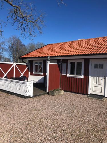 Casa roja y blanca con puerta blanca y porche en Skattegårdens Gästhus en Falköping