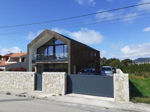 a house with a large window and a fence at Cork House in Vila Praia de Âncora