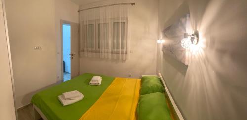 una piccola camera con un letto verde e giallo di Makera a Tivat