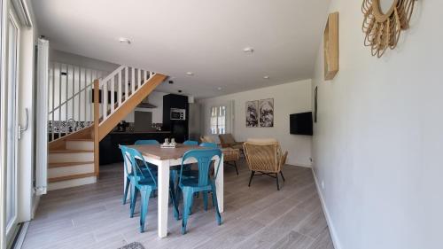une salle à manger avec une table et des chaises bleues dans l'établissement La Grange, à Seraincourt