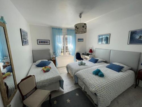 ビダールにあるAppartement entre 2 plagesのベッドルーム1室(ベッド2台、椅子、鏡付)