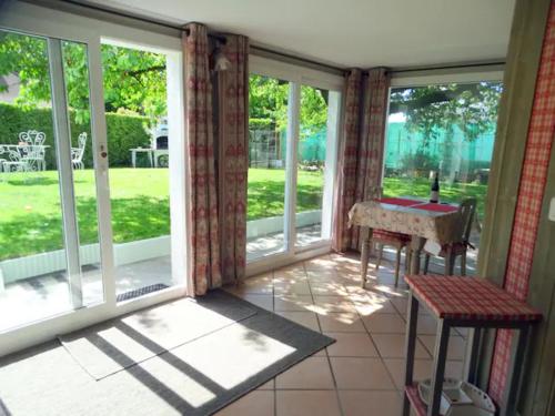 un porche grillagé avec une table et des fenêtres dans l'établissement Appartement 35 m² bord de lac Aix les Bains (73), à Aix-les-Bains