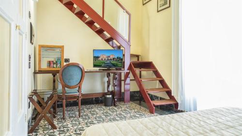 a room with a desk with a computer and a staircase at Villa Signorini Hotel in Ercolano