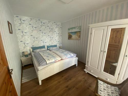 a bedroom with a bed with blue and white wallpaper at Ferienwohnung Emily in Ahlbeck