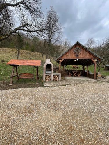 a wooden pavilion with a picnic table and a bench at Casa Titiana Suncuius in Şuncuiuş