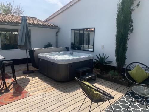 a hot tub sitting on a wooden deck at Beach Cottage in Le Bois-Plage-en-Ré