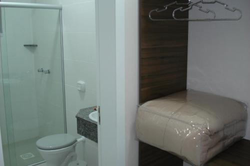 a bathroom with a toilet and a shower and a sink at Brisa Parque Hotel in Erechim