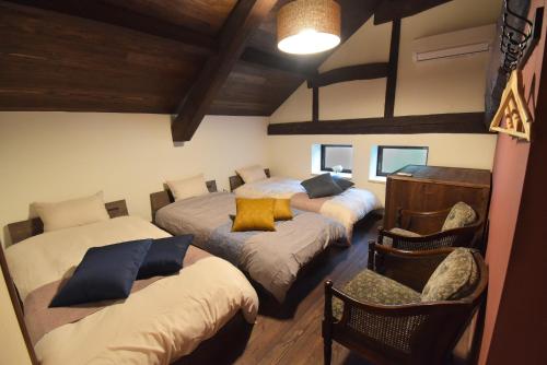 een slaapkamer met 3 bedden en een stoel bij Aburaya Bettei - Vacation STAY 50810v in Beppu