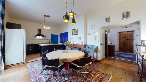 a kitchen and dining room with a table and chairs at Château Porthos Tranquillité des Pyrénées in Lanne en Barétous
