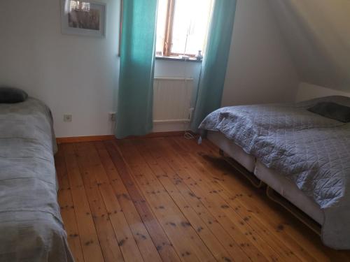 1 dormitorio con 2 camas y suelo de madera en Gotland, Hästgård i Stånga, en Stånga