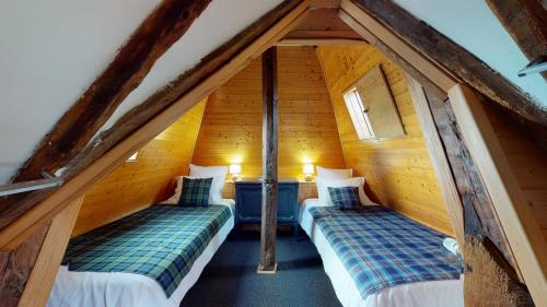 a room with two beds in a attic at Château Porthos Tranquillité des Pyrénées in Lanne en Barétous