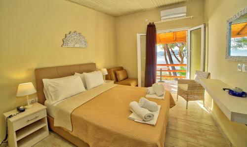 
a bedroom with a bed, chair, and table in it at Venus Beach Hotel in Nea Stira
