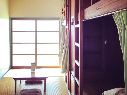 una stanza con tavolo e ampia finestra di Amanohashidate Youth Hostel a Miyazu