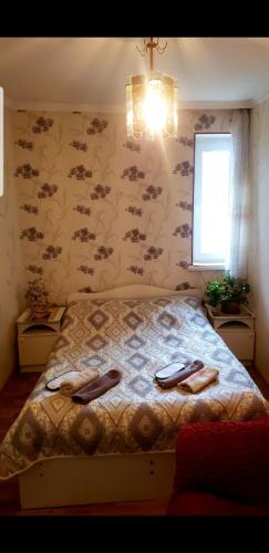 a bedroom with a bed with two shoes on it at Guest House Dodo in Kazbegi
