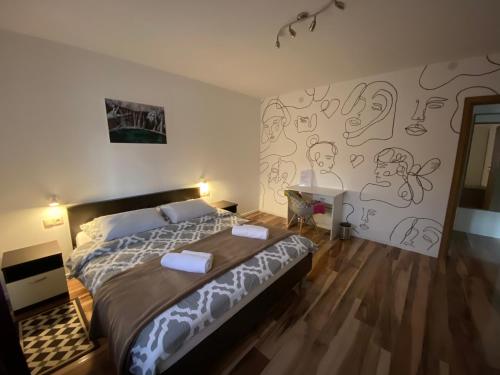 a bedroom with a bed and a wall with drawings on it at Apartment Liso in Seliste Dreznicko