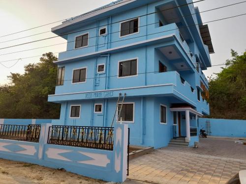 a blue building with a fence in front of it at Shanaya Holiday Apartment in Benaulim