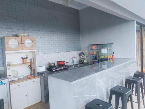 une cuisine avec un comptoir et des tabourets. dans l'établissement RD Cottage Hills, à Cihideung