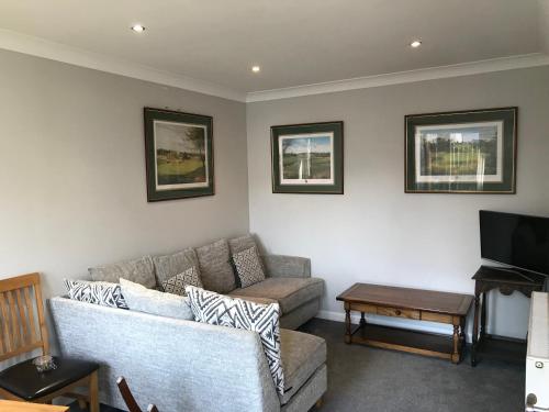 a living room with a couch and a tv at 2 The Old Scout Hall in Blairgowrie