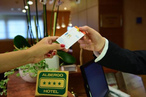 
a person holding a piece of paper with a smiley face at Hotel Raffaello in Milan
