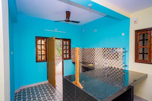 a kitchen with blue walls and a counter top at Shanaya Holiday Apartment in Benaulim