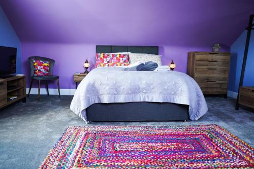 a purple bedroom with a bed and a rug at The Art Bank in Dalbeattie