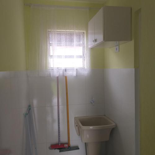 a bathroom with a sink and a toilet and a window at Jane Ilha in Ilha Comprida