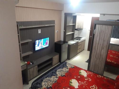 een kleine kamer met een bed en een televisie bij Apartemen Riverview Residence Jababeka at KiNGDOM Rent Apartment Solution in Cikarang