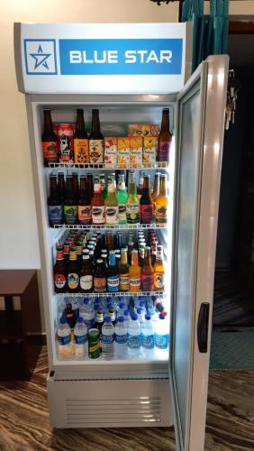 a refrigerator filled with lots of different types of drinks at Tropical Wave Hostel Morjim in Morjim