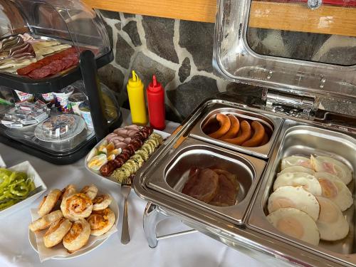 una mesa cubierta con bandejas de diferentes tipos de alimentos en Penzión Darinka, en Poprad