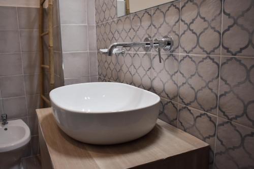 a bathroom with a large white bowl sink on a wooden counter at A Casa Ru Mare in Castellammare del Golfo