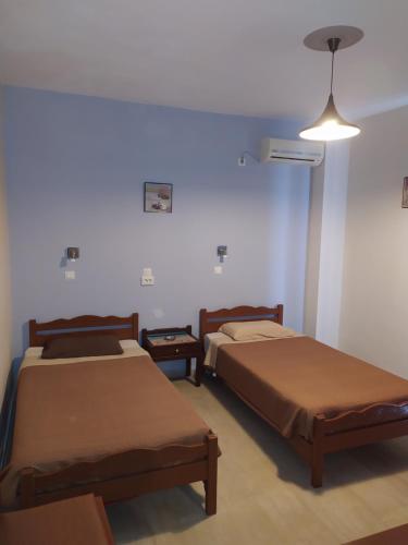 カルダメナにあるAnna Maria Apartmentsのベッド2台と照明器具が備わる客室です。