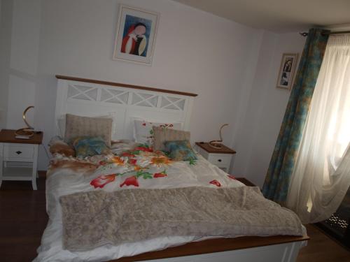 ein Schlafzimmer mit einem großen Bett mit einer weißen Bettdecke in der Unterkunft Amavera Apartment in Târgu Jiu