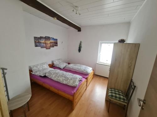2 Einzelbetten in einem Zimmer mit Fenster in der Unterkunft Große rustikale Ferienwohnung am Stadtrand von Röbel an der Müritz mit Balkon in Röbel