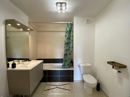 a bathroom with a sink and a toilet and a tub at Bel Appartement lumineux à 5 minutes d'Annecy in Seynod