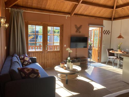 a living room with a blue couch and a table at B&B Porcini in Ermelo