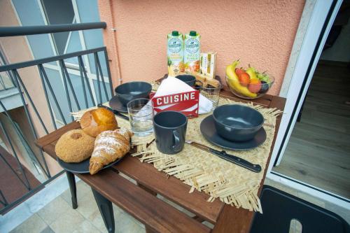 una mesa con pan y bebidas en el balcón en Catania Centre Urban Art B&B, en Catania