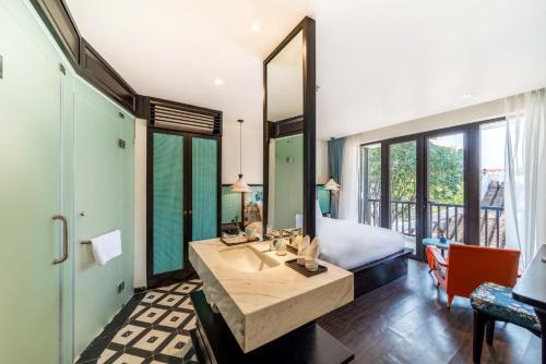 a bedroom with a bed and a large mirror at De An Hotel in Hoi An