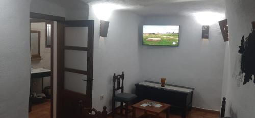 a hallway with a room with a television on a wall at Casa Cueva El Almendro in Pegalajar