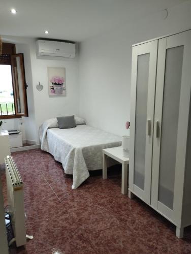 a white bedroom with a bed and a table at Roman Circus views Apartment in Tarragona