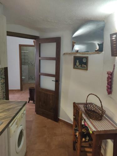 a kitchen with a door and a table and a laundry room at Casa Cueva El Almendro in Pegalajar