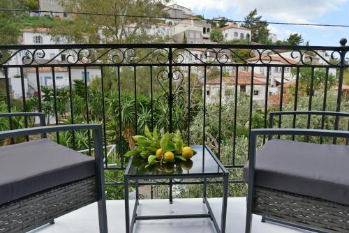 a table with a bowl of fruit on a balcony at Olivo luxury apartment in Hydra