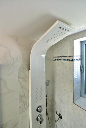 a bathroom with a shower with a glass door at Olivo luxury apartment in Hydra