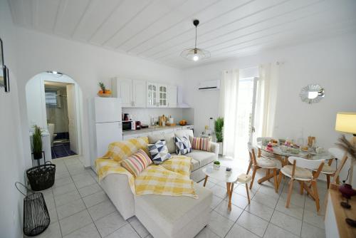Sala de estar blanca con sofá y mesa en Olivo luxury apartment, en Hydra