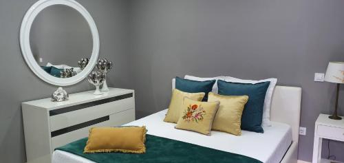 a bedroom with a bed with a mirror and pillows at Casa da Rocha in Paul do Mar