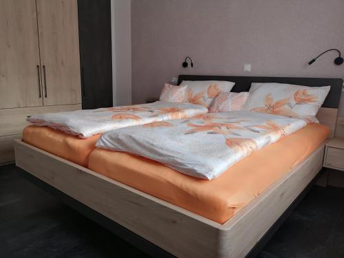 Lierschied的住宿－Ferienwohnung Rheinsteig，一张大床,上面有橙色和白色的床单